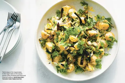  ?? DAVID MALOSH/ THE NEW YORK TIMES PHOTOS ?? Tahini steps in for mayonnaise in this vegan take on the classic potato salad, finished with fresh and charred scallions.
