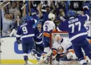  ?? CHRIS O’MEARA — ASSOCIATED PRESS ?? Lightning center Tyler Johnson, left, raises his hand after scoring a goal Tampa Bay’s 4-1 victory over Islanders.