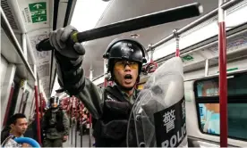  ??  ?? Riot police enter a train at the Tung Chung MTR station after protesters block the transport routes to Hong Kong Internatio­nal Airport. Photograph: Anthony Kwan/Getty Images