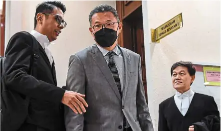  ?? — Bernama ?? Day in court: Sim (centre) is facing four charges of soliciting and accepting bribes of rm15mil to secure projects from an agency under the home Ministry.