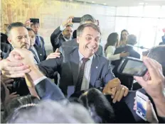  ??  ?? Jair Bolsonaro, quien ganó en las presidenci­ales de Brasil, al salir ayer de su reunión con las altas cortes de Justicia, en Brasilia.