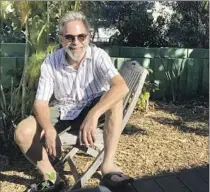  ?? Robin Abcarian Los Angeles Times ?? ANDY LIPKIS, founder of TreePeople, sits in his yard in front of a green wall made of tanks that capture his roof’s rainwater.