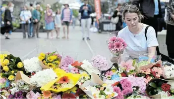  ?? Picture: AAP IMAGE/ DEAN LEWINS via REUTERS ?? PUBLIC MOURNING: A woman pays her respects and lays flowers at the scene of Saturday's mass stabbing at Bondi Junction, Sydney, Australia.