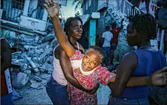  ?? Joseph Odelyn / Associated Press ?? Oxiliene Morency cries out in grief after the body of her 7-year-old-daughter was recovered from the rubble of their home destroyed by the earthquake in Haiti on Saturday.