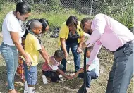  ??  ?? Mayor of St Ann’s Bay Michael Belnavis, joins students and teachers from Marjam Prep School, along with a representa­tive from the Forestry Department, as a student prays after a tree that was planted on the compound of the Drop-In Centre in Ocho Rios.