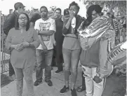  ?? LEE BERGQUIST / MILWAUKEE JOURNAL SENTINEL ?? Ald. Chantia Lewis (left) speaks at a vigil for Phillip Franklin, who died last week in a hit-and-run crash. Second from right is one of Franklin’s daughters, Azariah Franklin.