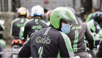  ??  ?? Market leader: A Grabbike driver rides on his motorbike in Jakarta, Indonesia. Grab has money to burn. Valued at Us$14bil, it is planning to raise more than Us$4.5bil in its latest funding round. — AP