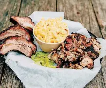  ?? [PHOTO BY MIA READE-BAYLOR, THE JOINT] ?? Ribs, pulled pork, mac and cheese and homemade pickles at the Joint.