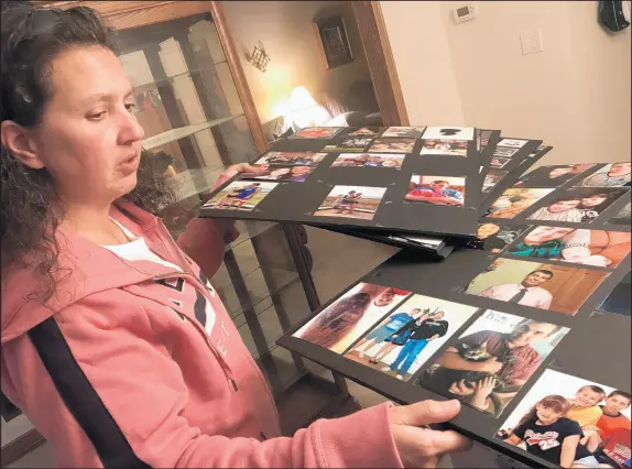  ?? JERRY DAVICH/POST TRIBUNE ?? Rachel Holland of Valparaiso looks through the photo collages from her son’s funeral.