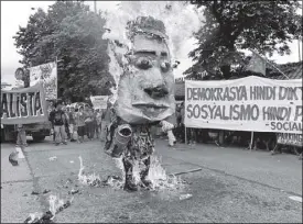  ?? BOY SANTOS ?? Activists burn an effigy of President Duterte during the SONA yesterday.