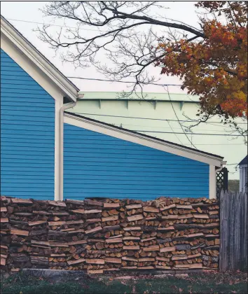  ?? TRISTAN SPINSKI / THE NEW YORK TIMES ?? Firewood is stacked next to a home in South Portland, Maine. Heating bills in the Northeast and Northern Plains, in particular, could be painful this winter.