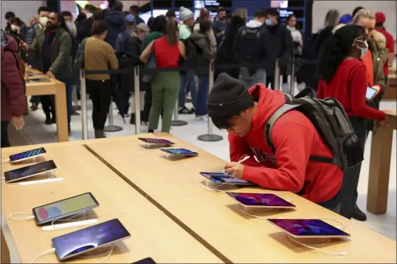  ?? JULIA NIKHINSON — THE ASSOCIATED PRESS ?? A person shops in an Apple store on Black Friday on Friday in New York.