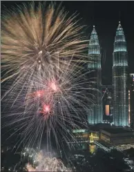  ?? SMOHD RASFAN / AGENCE FRANCE-PRESSE ?? Fireworks illuminate the sky near Malaysia’s Petronas Twin Towers during New Year celebratio­ns in Kuala Lumpur on Monday.
