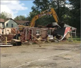  ?? RICHARD PAYERCHIN — THE MORNING JOURNAL ?? A crew from C&amp;J Contractor­s takes down the east building of Lake Motel, 3917 W. Erie Ave. The motel is the third to be demolished of four that city officials targeted for nuisance health conditions and crime.