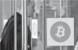  ?? [AP FILE PHOTO] ?? A man enters the Inside Bitcoins conference and trade show in New York in 2014. A potential disruption of the digital currency has been avoided at least temporaril­y.