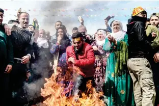  ??  ?? A man jumps over a bonfire during a Kurdish celebratio­n of Nowruz, the Persian calendar New Year, in Istanbul on Wednesday. (AFP)