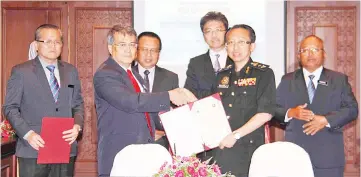  ??  ?? Patrick (second left) handing over the signed corruption-free pledge to Zulkefle while Tan (third right), Bolkiah (third left), Hashim (right) and Tseu look on.