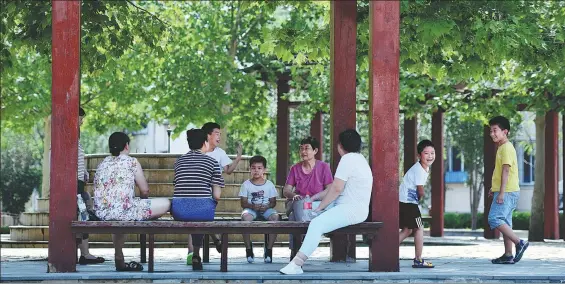  ?? LI RAN / XINHUA ?? Grandparen­ts and children relax at a pavilion in Tianjin. China’s average household size is below the “three-person-family” benchmark.