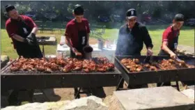  ?? RICHARD PAYERCHIN — THE MORNING JOURNAL ?? Chef de Cuisine James Pogorelc, second from right, directs traffic over the grill to prepare food for the Valor Home BBQ &amp; Concert held at Pogie’s Clubhouse on Jefferson in Amherst. At least 100 people came out for the afternoon supper of barbecued chicken and sides, with music on the deck and patio, to help raise money for the new Valor Home center for women veterans.