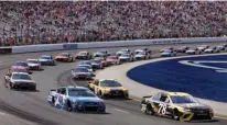  ?? Associated Press ?? n Driver Martin Truex Jr., bottom right, leads the pack going into the first turn of the NASCAR Cup Series 301 auto race Sunday at the New Hampshire Motor Speedway in Loudon, N.H.