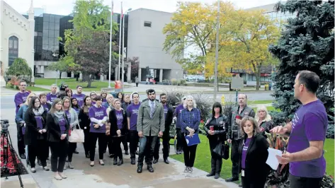  ?? ALLAN BENNER/POSTMEDIA NEWS ?? Wearing purple shirts with Break the Silence printed on them, a few dozen people joined St. Catharines mayor Walter Sendzik, at right, to recognize 25 years of the Child Abuse Awareness and Prevention campaign.