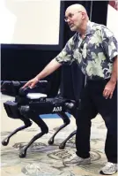  ?? AP FOTO / CHARLES KRUPA ?? Boston Dynamics founder Marc Raibert shows the SpotMini robot during a robotics summit in Boston.