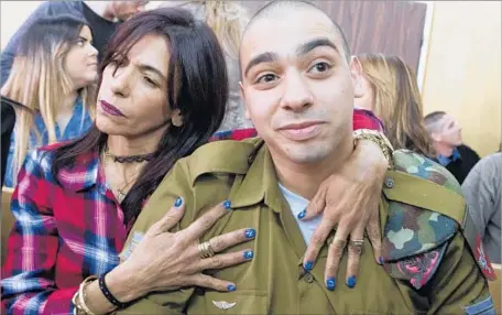  ?? Jim Hollander Pool Photo ?? IN TEL AVIV, Elor Azaria is embraced by his mother, Oshra, at the start of his sentencing hearing. His case has gripped the nation.