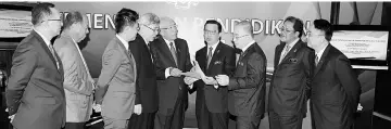  ??  ?? Mahdzir (fifth left) hands over documents on the constructi­on of 10 new Sekolah Jenis Kebangsaan Cina to Liow after announcing it at his office as others look on. — Bernama photo