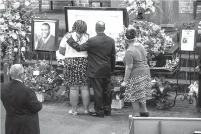  ?? Shaban Athuman/The Dallas Morning News via AP ?? ■ Mourners console each other during the public viewing before the funeral of Botham Shem Jean at the Greenville Avenue Church of Christ on Thursday in Richardson, Texas. Jean was shot and killed by a Dallas police officer in his apartment last week in Dallas.