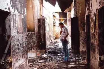  ?? Najim Rahim / Associated Press ?? A Doctors Without Borders employee looks over the charred remains for the organizati­on’s hospital in October. A U.S. airstrike mistakenly hit the facility instead of a different building occupied by the Taliban.