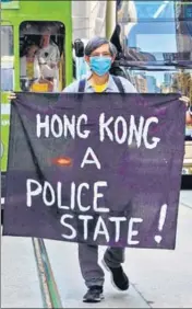  ?? AP ?? ■ A protester holds up a banner during a rally to remember Chow Tsz Lok in Hong Kong on Friday.