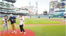  ?? AFP-Yonhap ?? U.S. Freeski Olympian Maggie Voisin, left, and U.S. Snowboard Olympian Kyle Mack, right, are interviewe­d by Atlanta Braves In Game Host Mark Owens after an earlier announceme­nt of a partnershi­p between the Braves and the U.S. Ski & Snowboard prior to the game between the Atlanta Braves and the Washington Nationals at SunTrust Park in Atlanta, Ga., Thursday.