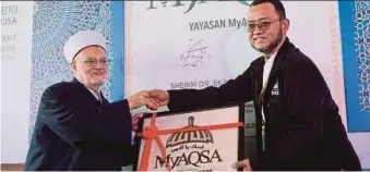  ?? BERNAMA PIC ?? Al-Aqsa Mosque Grand Imam Sheikh Ekrima Said Sabri (left) accepting a souvenir from MyAQSA Foundation chief executive officer Noorazman Mohd Samsuddin after the launch of the foundation in Putrajaya yesterday.