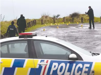  ?? ALAN GIBSON / NEW ZEALAND HERALD VIA THE CANADIAN PRESS ?? Police investigat­e in the carpark of the Te Toto Gorge lookout south of Raglan, N.Z., Friday after an Australian man was killed in what police believe was a random attack on the van that he and his Canadian fiancée were sleeping in.