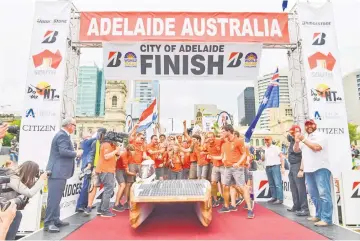  ??  ?? Crew members of the Dutch team ‘Nuon’ celebrate after winning the World Solar Challenge in Adelaide. — AFP photo