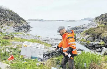  ?? FOTO: DPA ?? Der Plastikmül­l häuft sich auf einer kleinen Insel vor der Stadt Bergen. Selbst ein alter Kühlschran­k hat es bis ans Ufer geschafft.