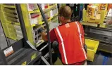  ?? KARA DRISCOLL / STAFF ?? A worker loads products at the Amazon facility in Etna, Ohio.