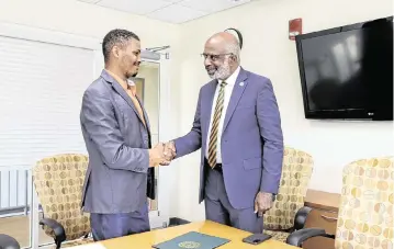  ?? ERNEST NELFRARD Courtesy Florida A&M University ?? Gregory Gerami (left), president and CEO of Batterson Farms Corp, shakes hands with Florida A&M University President Larry Robinson.