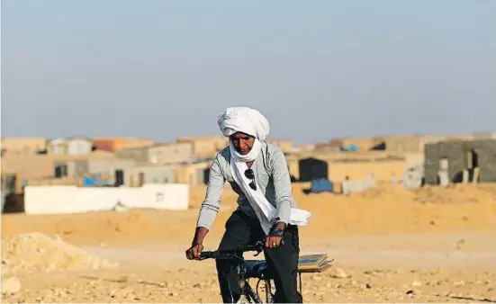  ?? MANUEL LORENZO ?? Exili inhòspit. Un home desplaçant-se amb bicicleta pel camp de refugiats de Bojador