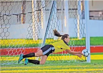  ?? GARY CURRERI/CORRESPOND­ENT ?? Sydney Ford, 13, of Indian Ridge Middle School, dives to her left to make her second save in the penalty kick shootout that gave the Jaguars the county girls soccer championsh­ip.