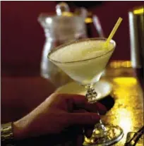  ?? THE ASSOCIATED PRESS ?? A tourist holds a daiquiri made with Cuban Havana Club rum at the Floridita bar in Havana, Cuba.