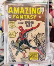  ?? Robyn Beck/AFP via Getty Images ?? A Julien's Auctions appraisal consultant displays the "Amazing Fantasy #15" comic book autographe­d by Stan Lee at Julien's Auction House in Beverly Hills, California, on Nov. 13, 2018. “Amazing Fantasy #15” features the very first appearance of Marvel's Spider Man. A copy was stolen in Shelton but later recovered.