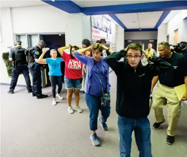  ?? ASSOCIATED PRESS ?? In this Friday June 9, 2017 file photo, students are led out of school as members of the Fountain Police Department take part in an Active Shooter Response Training exercise at Fountain Middle School in Fountain, Colo. The nation’s two largest teachers unions want schools to revise or eliminate active shooter drills, asserting Tuesday, Feb. 11, 2020 that they can harm students’ mental health and that there are better ways to prepare for the possibilit­y of a school shooting.