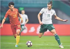  ??  ?? Gareth Bale (right) of Wales competes for the ball with Wang Shenchao of China during their China Cup Internatio­nal Football Championsh­ip semi-final in Nanning in China’s southern Guangxi region. — AFP photo