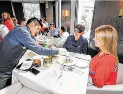  ??  ?? Potente’s Edvin Tumax put the finishing touches on Judge Mike Rozell and daughter Amy Rozell’s meal before they left for Minute Maid Park for the start of Game 2 of the ALDS.