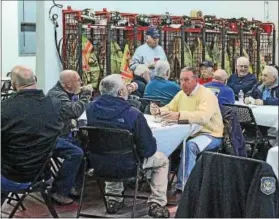  ?? CHRIS BARBER — DIGITAL FIRST MEDIA ?? First responders sit at tables in the bay of the West Grove Fire Company and enjoy turkey dinners.