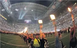  ?? David J. Phillip Associated Press ?? AUDIENCE members wave torches on the field as Lady Gaga performs.