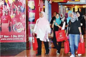  ??  ?? Gearing up Delegates passing by posters of the 66th Umno General Assembly at the Putra World Trade Centre in Kuala Lumpur. The assembly begins tomorrow. — Bernama