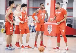  ?? ROBERTO E. ROSALES/JOURNAL ?? UNM Lobos, from left, Anthony Mathis, Clay Patterson, Drue Drinnon and Keith McGee listen to assistant Brandon Mason, right, at Friday’s practice.