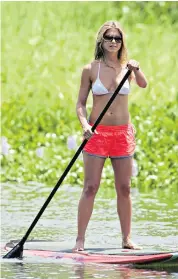  ??  ?? Holiday workout: actress Jennifer Aniston enjoys stand-up paddleboar­ding, the world’s fastest-growing watersport